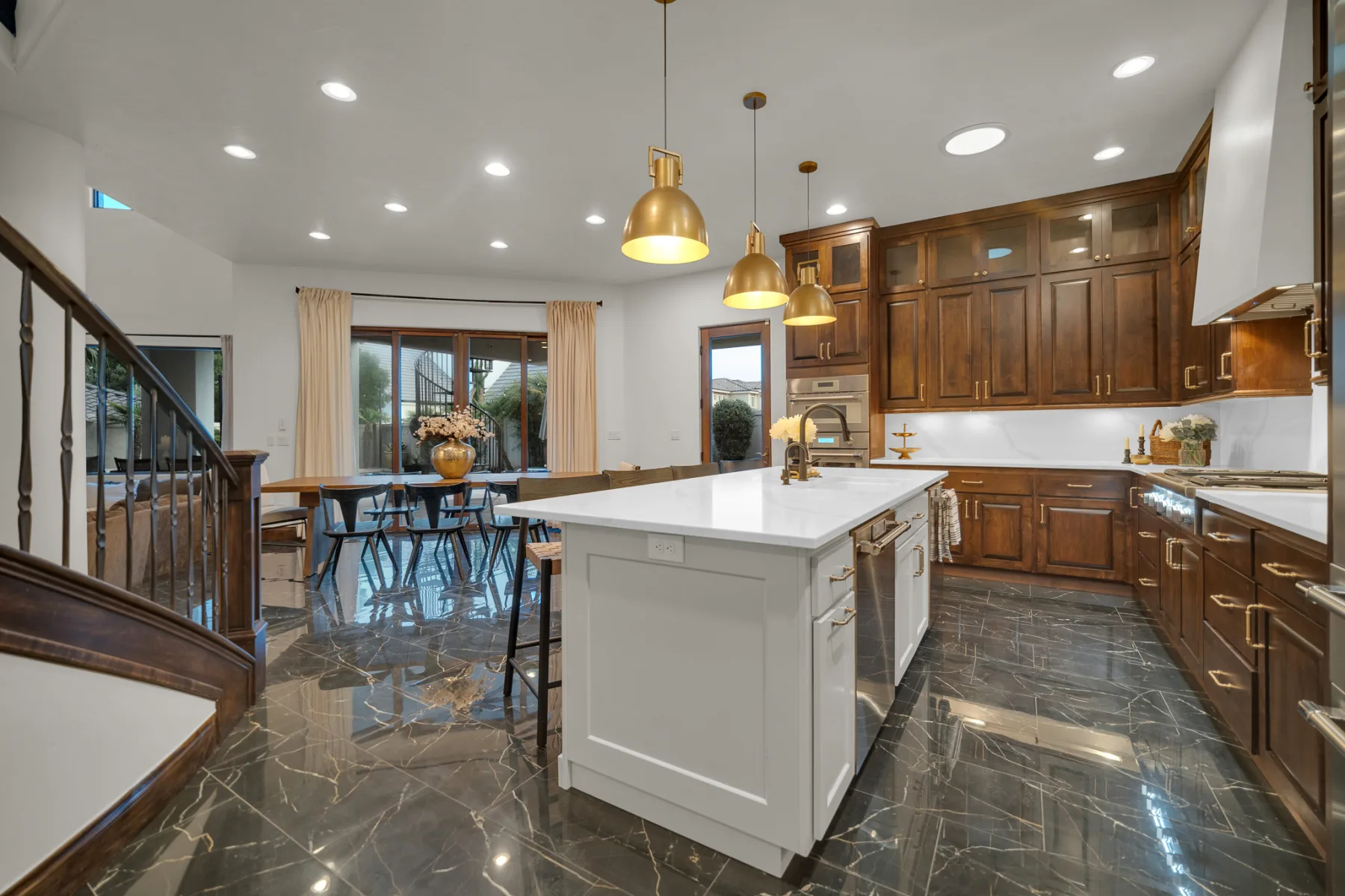 Large kitchen with dark wood cabinetry and white island